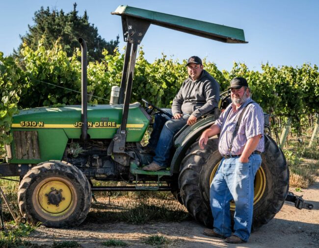 Two men with a John Deere tractor at Emeritus Vineyards