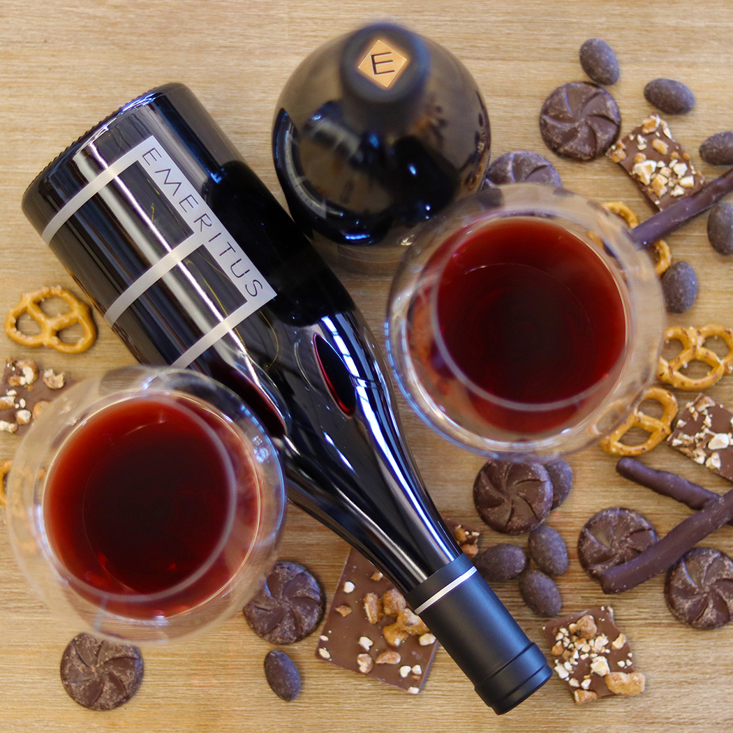 overhead view of two bottles and glasses of Pinot NOir and chocolate snacks